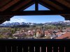 Die Aussicht zeigt ein Dorf mit einem weißen Kirchengebäude. Umgeben von Bergen an einem sonnigen Tag. Es zeigt den Ausblick vom Balkon der Wohnung Himmeleck.