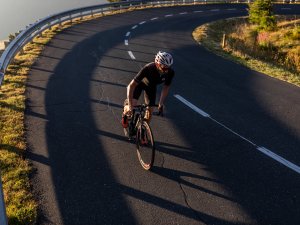 Rennradfahrer genießt eine Ausfahrt bei Sonnenaufgang