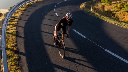 Rennradfahrer genießt eine Ausfahrt bei Sonnenaufgang