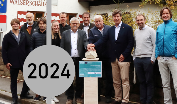 Meilenstein 2024 Eine Gruppe von Menschen feiert den Start eines Workshops an der Walserschanz im Jahr 2024.