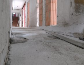 Der Flur eines alten Gebäudes zeigt den Zustand während der Renovierung. Das Licht scheint durch die Schlitze.