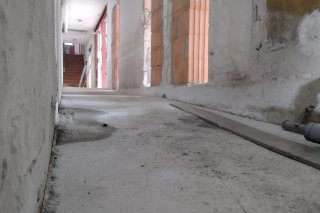 Der Flur eines alten Gebäudes zeigt den Zustand während der Renovierung. Das Licht scheint durch die Schlitze.