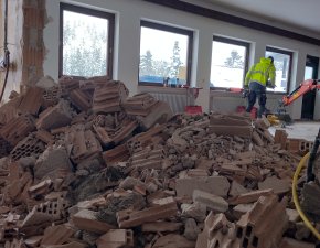 Renovierungsarbeiten mit Abbruchmaterial in einem Raum. Die Fenster lassen Licht hinein.