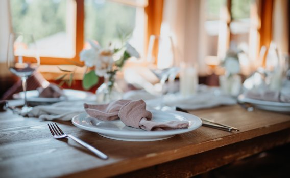 Stilvolle Tischdekoration für exklusive Abende und unvergessliche Momente Stilvoll gedeckter Tisch in gemütlicher Atmosphäre, perfekt für besondere Anlässe, romantische Abende oder exklusive Dinner-Events auf der Wannenkopfhütte.