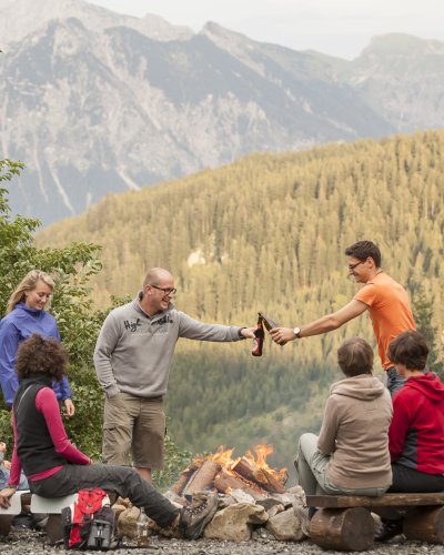 Bei einem kühlen Radler oder Bier lässt es sich in geselliger Runde am Lagerfeuer gut aushalten - noch dazu bei so einem tollen Panoramablick!