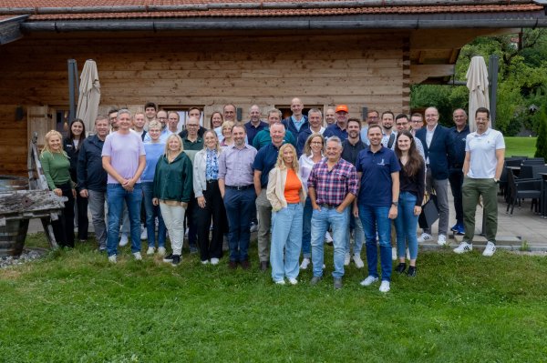 Die Vertreter der Organisatoren posiert vor einem Holzgebäude im Freien während des DSV-Workshops. Gruppenfoto im Rahmen des DSV-Workshops der Weltcup-OKs