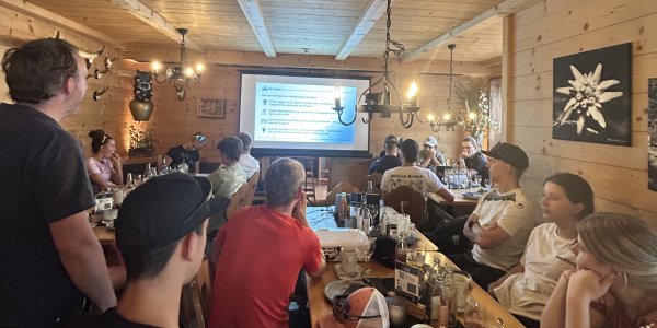 Der Generalsekretär des Weltcup Ofterschwang gibt einen Vortrag zum Thema Nachhaltigkeit im Rahmen eines Workshops in einem Restaurant. Workshop im Rahmen des Plan B-Camps
