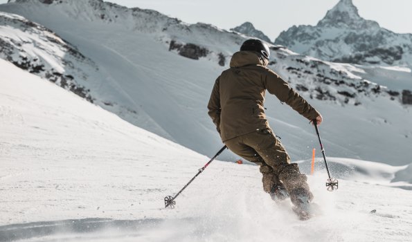 Skifahren auf dem Nebelhorn an einem klaren Tag Ein Skifahrer gleitet durch den frischen Schnee an einem sonnigen, klaren Tag unter blauen Himmel