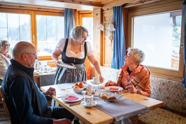 Eine Servicemitarbeiterin bringt beim Frühstück den Kaffee an den Tisch