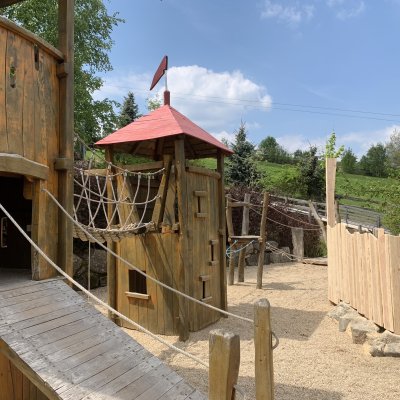 Der Spielplatz besteht aus Holz und hat Kletterelemente. Kinder können hier spielen und ihre Zeit im Freien verbringen.